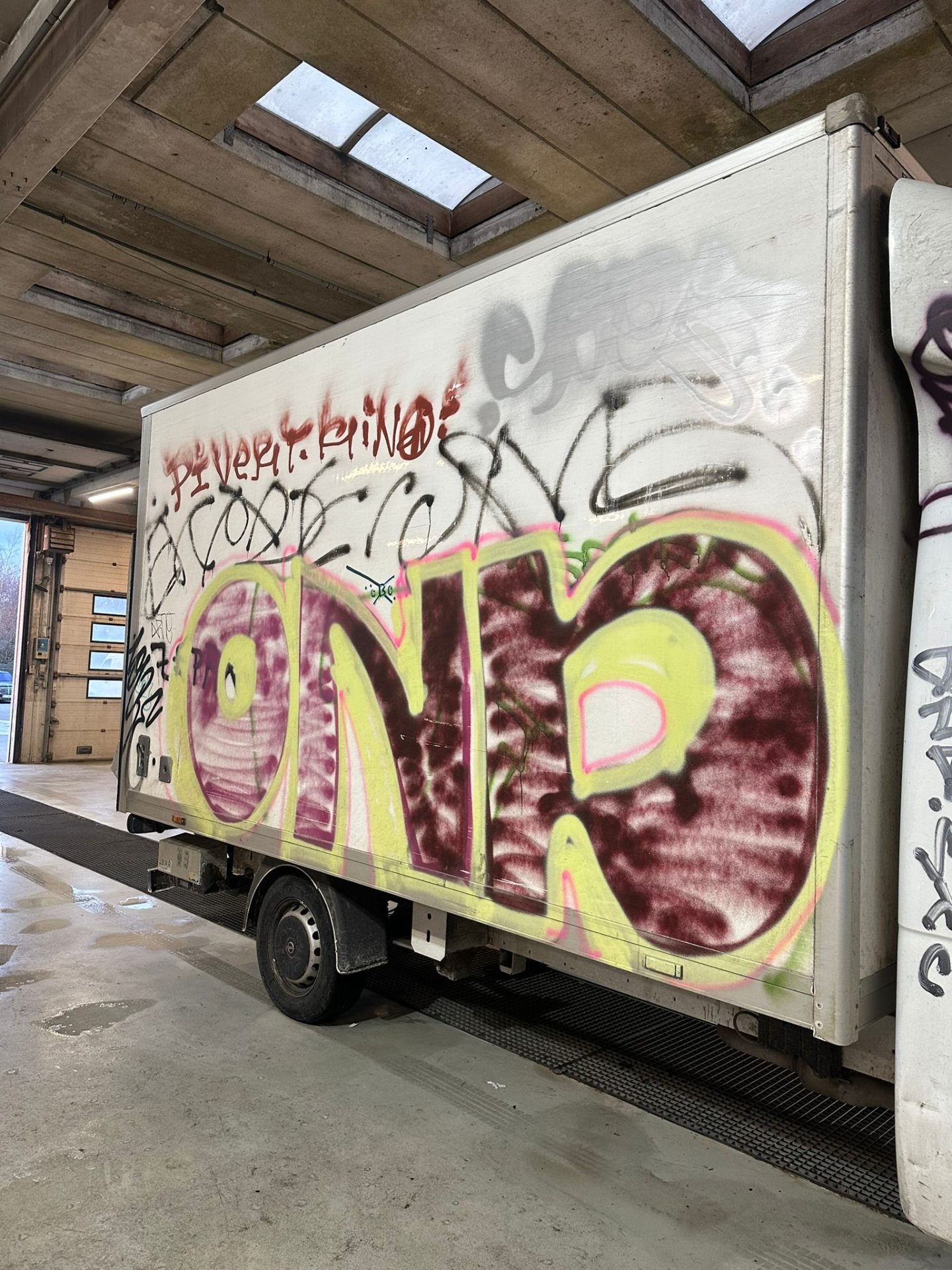 Lastbil med farverig graffiti før graffitifjernelse