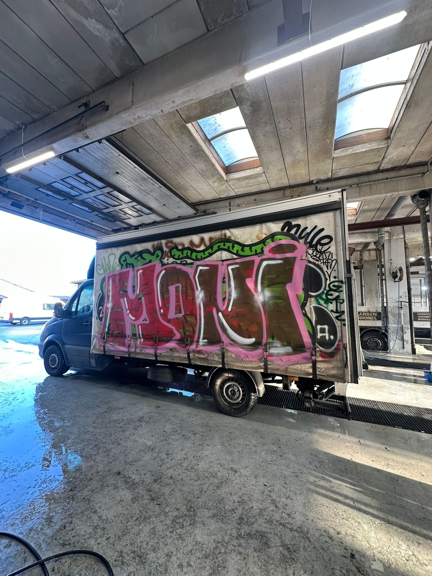 Presenning på lastbil med Amour graffiti før rens